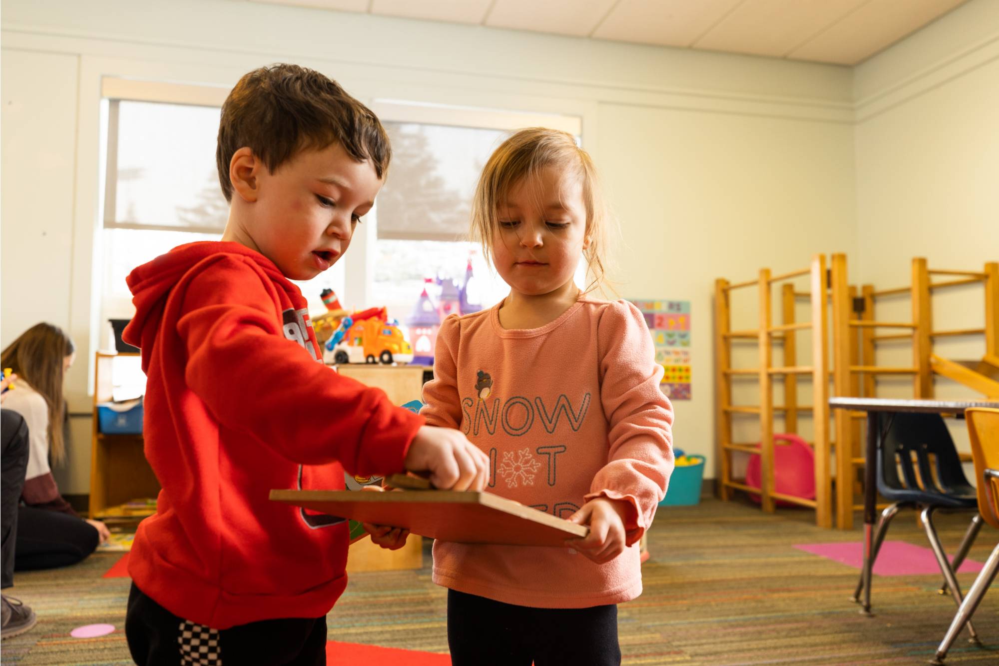 Children sharing puzzle while playing